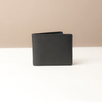 Black leather wallet on a beige background