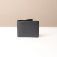 Closed Black leather wallet on a beige background