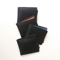 Four black leather wallets with different interior color on a white background