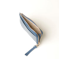 Blue zippered card case with gold zipper pull on a white background