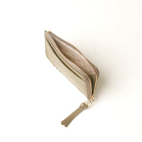 Beige zippered card case with quilted interior on a white background