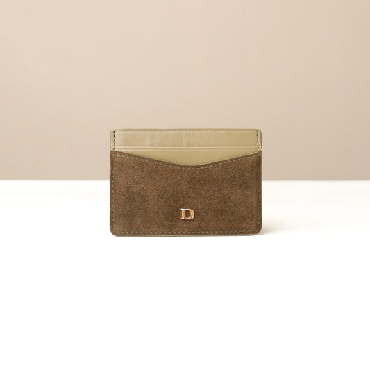 green suede Danilos cardholder with a beige interior on a white background