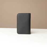 back view of a black Danilos Pebble leather Document Portfolio Alfaro on a beige background