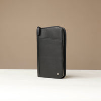 Side view of a black Danilos Pebble leather Document Portfolio Alfaro with zipper on a beige background