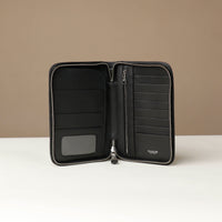 Open view of a black Danilos Pebble leather Document Portfolio Alfaro with eight card slots, zipper pocket, main pocket with three card slots on a beige background