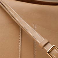 Strap and stitching detail of tan Penelope Sr. handbag – gold-tone hardware and minimalist design