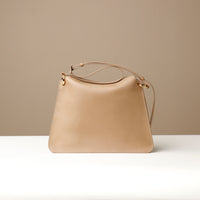Strap and stitching detail of tan Penelope Sr. handbag – gold-tone hardware and minimalist design