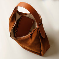 Angled shot of tan suede Mia Minimale – side pleat and tonal strap shown in profile