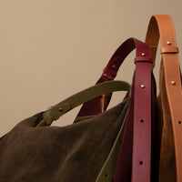 Suede hobo straps in detail – olive, burgundy, and tan handles with gold rivets