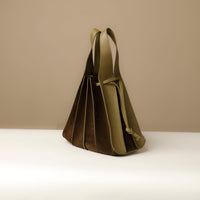 Side angle of green olive Suede Papillon Sr. – elegant sculptural profile with wide-set handle