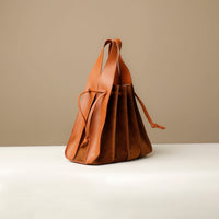 Close-up of tan Suede Papillon Sr. top handles – structured suede and leather craftsmanship