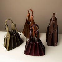 Group of Suede Papillon bags in black, olive, and burgundy – sculptural suede bucket bags by Danilo’s