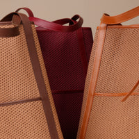Three bags with brown handles and mesh patterns on a beige background