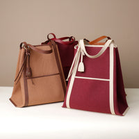 Two handbags, one brown and one red with white accents, on a neutral background.
