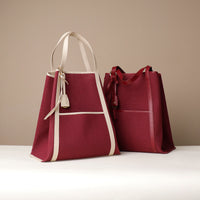 Two red handbags with white accents on a beige background