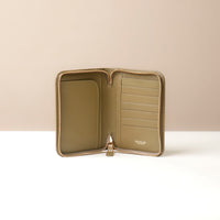 Front view of a green passport case lovable with a Danilos logo on a beige background, 8 card slots and 2 pockets