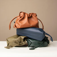 Stack of Danilo’s Sassy Satchel bags in terracotta, navy, olive, and forest green – ruched leather drawstring purses handcrafted in premium nappa leather