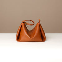 Close-up of Danilo’s gold emblem on brown leather Silueta Bag