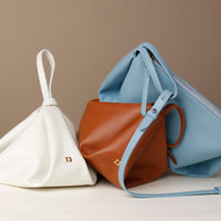 Side view of brown Silueta Bag – minimalist design with triangular fold and wristlet strap