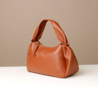 Angle view of brown Aurora Bag – artisanal pleating and top-stitched handle detai