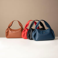 Display of Aurora Soft Bags in brown, red, and black – designer sculptural leather bags for everyday carry