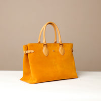 Yellow suede leather danilos  tote bag with yellow handles on a beige background