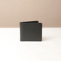 Black leather wallet on a beige background