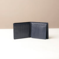 Dark Blue leather  Isa wallet open on a beige background