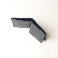 Dark blue leather Isa wallet open upper view on a white background