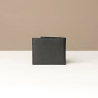 Back view of a black nappa leather Milano wallet over a beige background