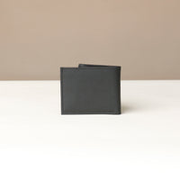 Back view of a black pebble leather Milano wallet over a beige background