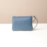 Blue wristlet pouch with a strap on a beige background