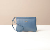 Blue wristlet pouch with a strap on a beige background