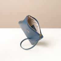 Blue wristlet pouch with a strap on a white surface