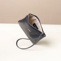 Navy blue wristlet pouch with a strap on a white surface