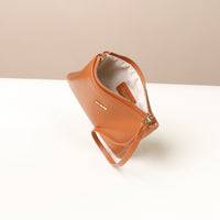 Brown leather pouch with zipper on a white surface