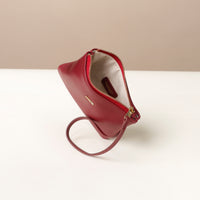 Red wristlet pouch with a strap on a white surface