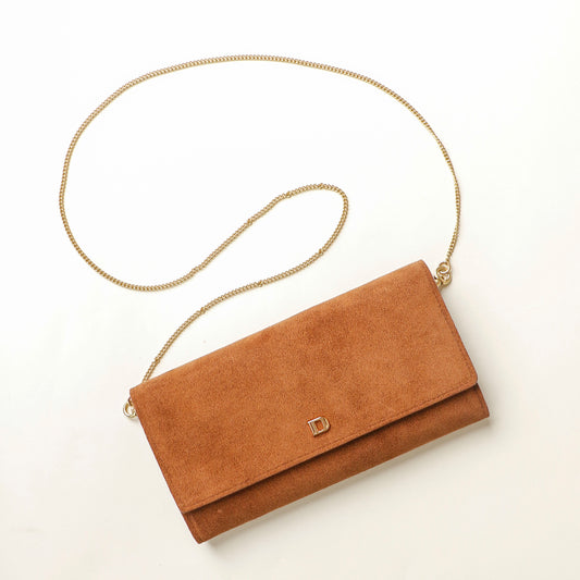 Brown suede Danilos clutch with a gold chain strap on a white background