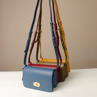 Collection of colorful handbags with handles on a neutral background