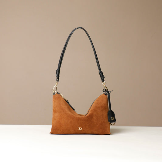Brown Danilos handbag with black strap on a beige background