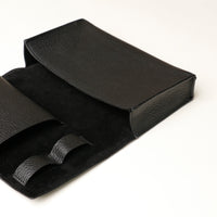 Close up view of a open black Danilos Pebble executive accessory holder linea on a beige background