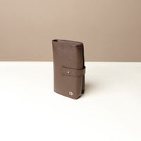 Side view of a brown Danilos Pebble executive accessory holder linea on a beige background