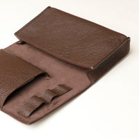 Close up view of a brown Danilos Pebble executive accessory holder linea on a beige background