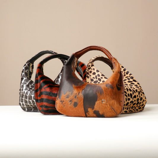 Three Danilos handbags with animal print patterns on a beige background