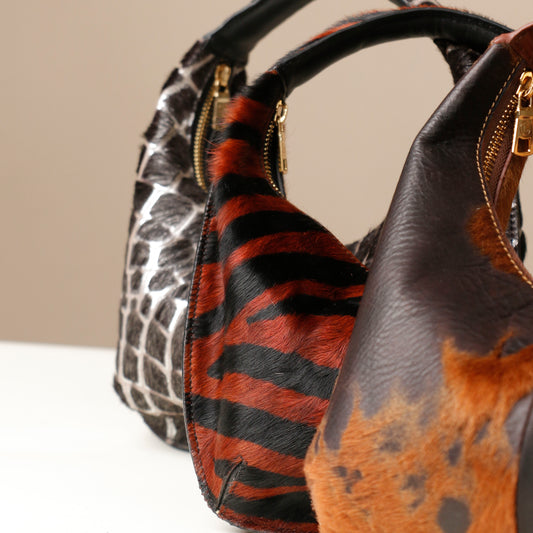 Three Danilos handbags with unique animal patterns on a neutral background