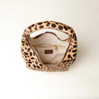 upper view opened hair on leather Leopard print danilos  handbag with gold zipper on a white background