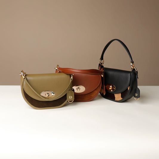 Three leather Danilos handbags in green, brown, and black on a white surface with a beige background