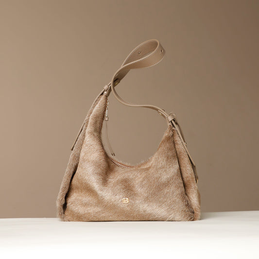 Beige hair on leather Danilos handbag on a beige background