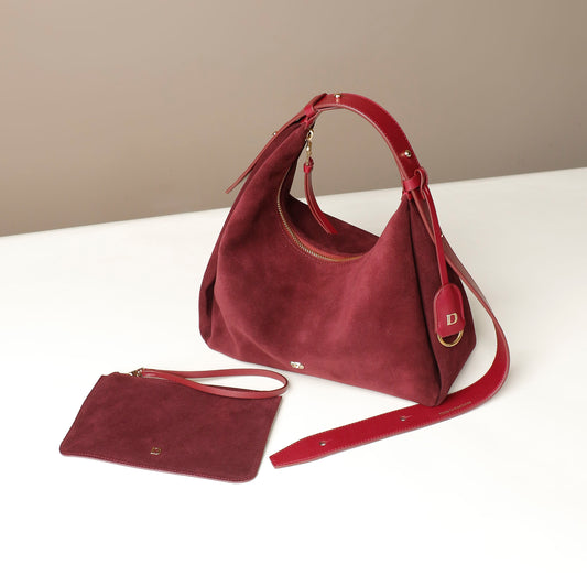 red suede leather danilos handbag with matching pouch on a white surface
