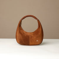 Brown round suede leather danilos handbag on a beige background